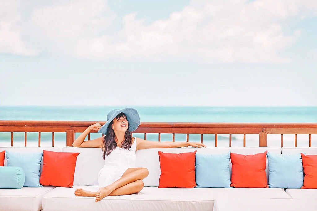 woman sitting by the beach smiling