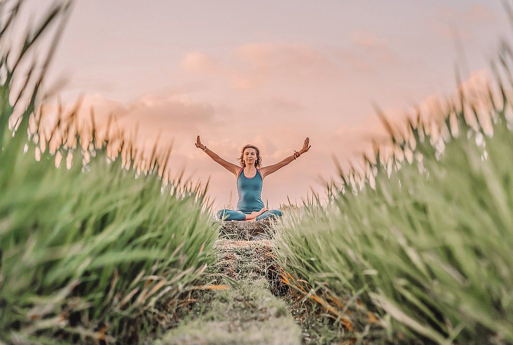 woman doing yoga on the beach