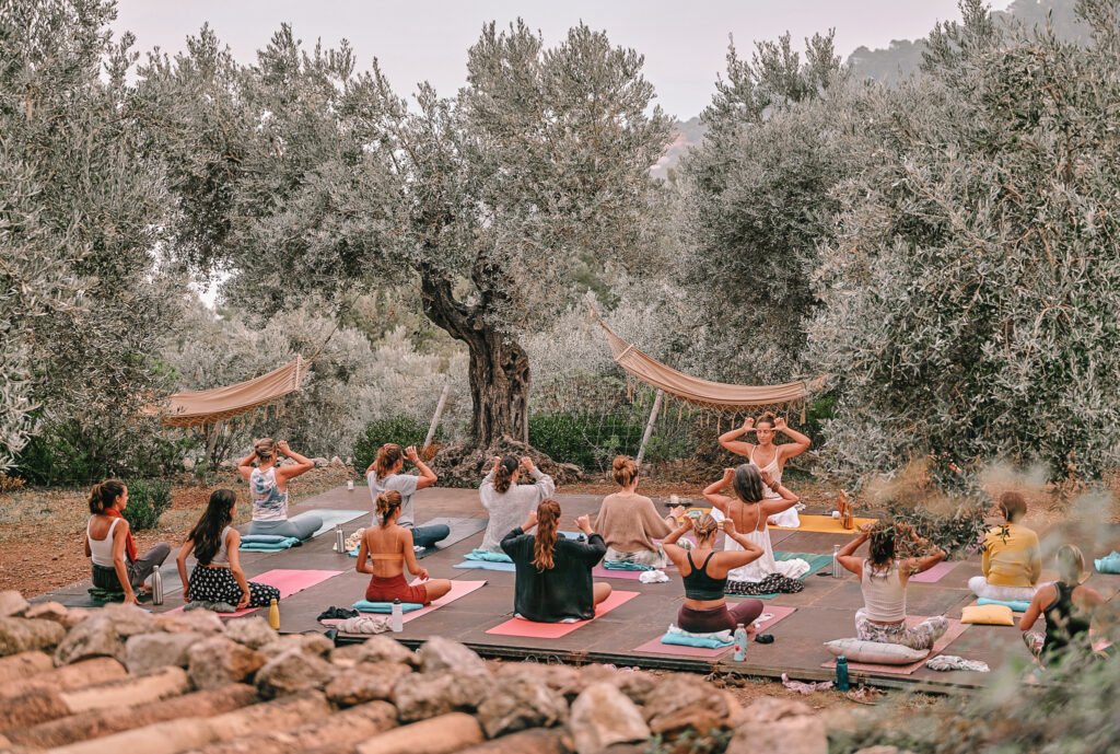 solo yoga retreats for women - group of women doing yoga in the nature