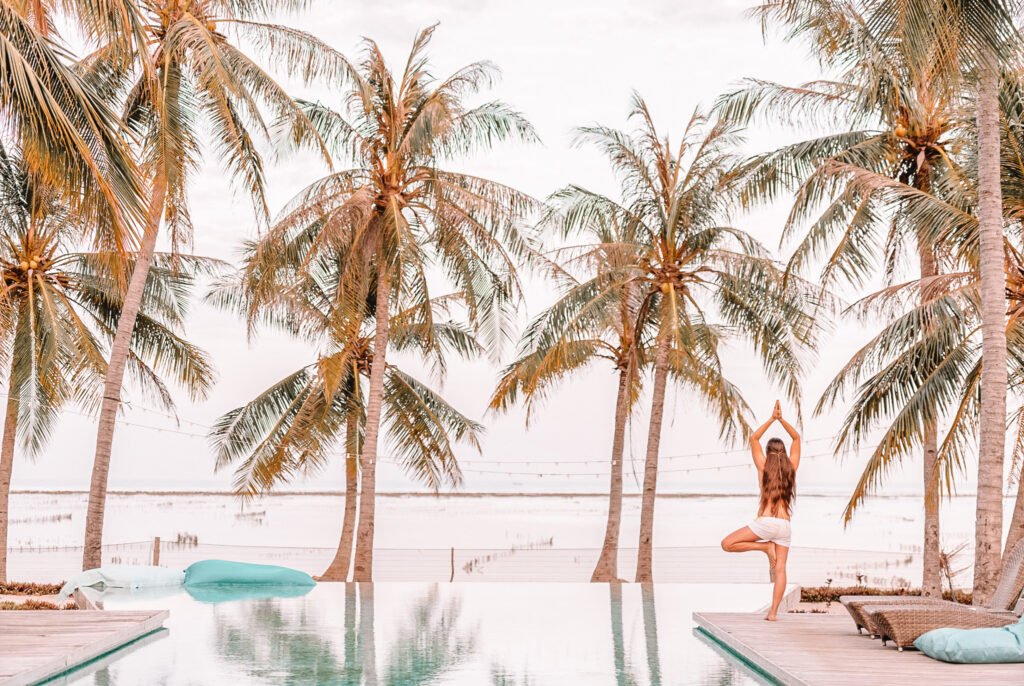 woman doing yoga by the pool