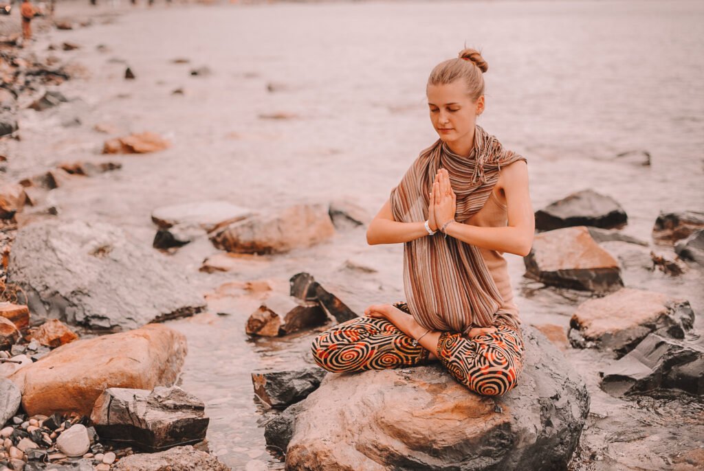 young woman doing yoga by the river