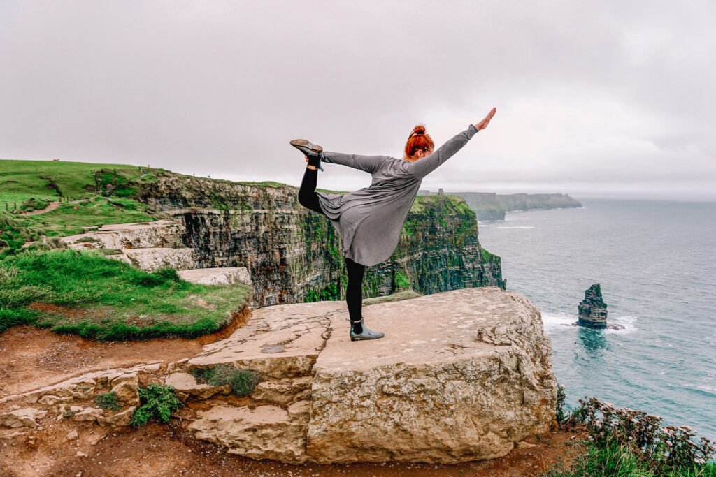 woman doing yoga on the cliff