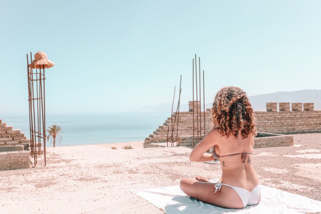 woman doing yoga with the view of the ocean